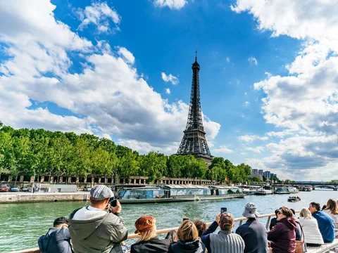 Battello della crociera sulla Senna che passa davanti alla Torre Eiffel